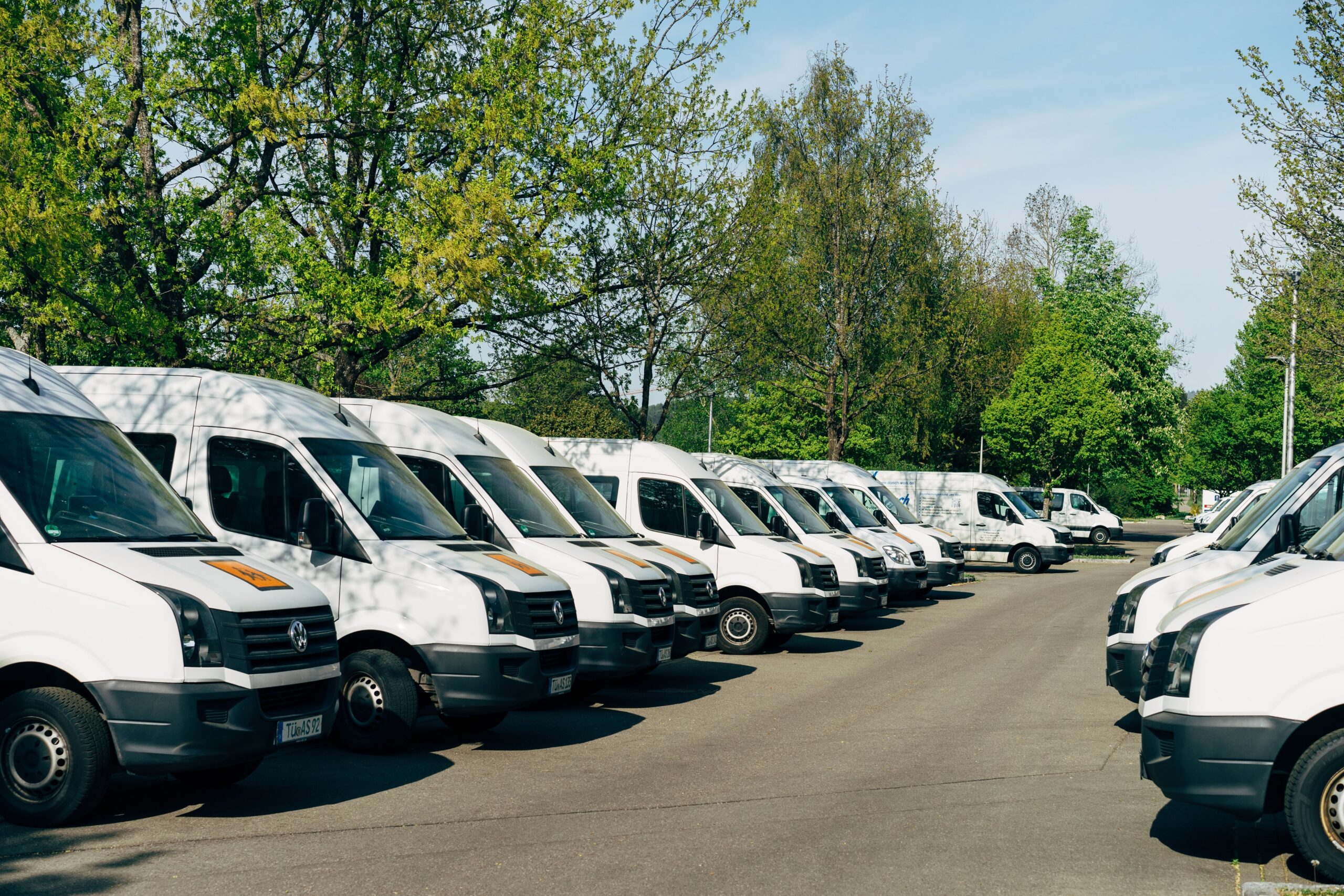 a row of white delivery vans all parked beside each other.