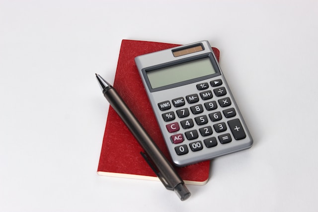 a calculator on top of a red notebook